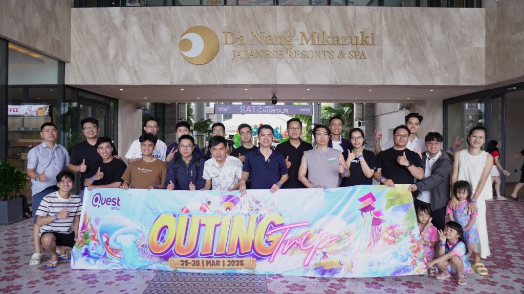 Team standing together and holding a banner while taking a group outing picture