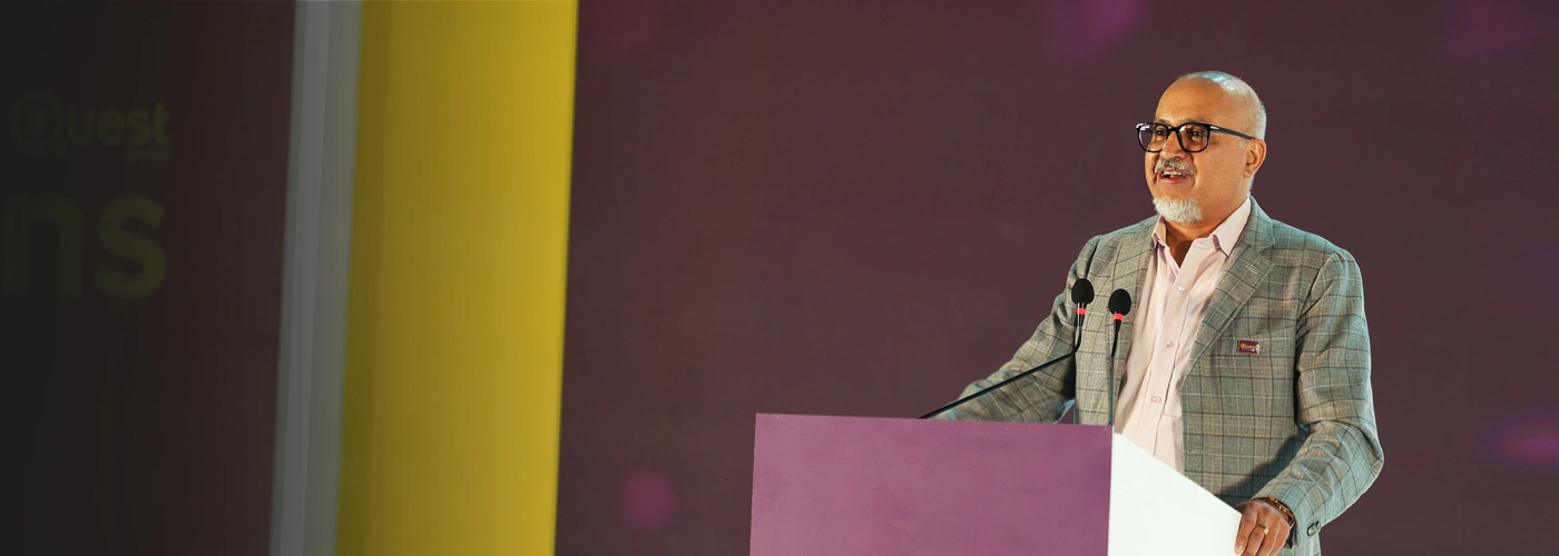 Ajit speaking at a Quest Global event