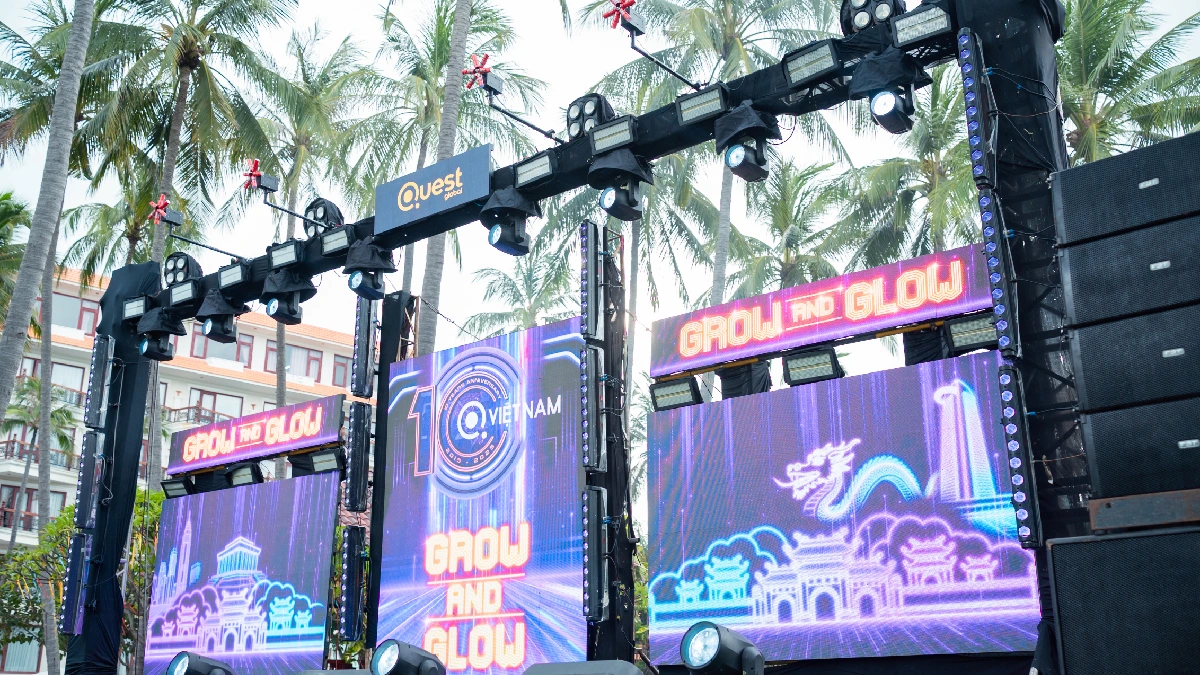 Outdoor event stage setup with large LED screens displaying "GROW AND GLOW