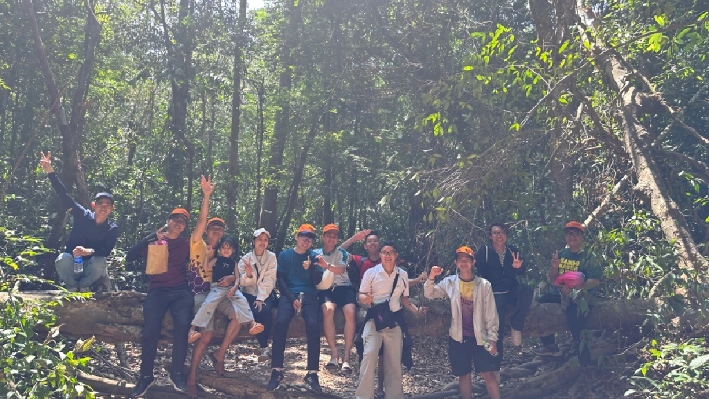 A group of people posing together during an outing in a forest